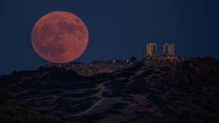 Der Supermond neben den Resten eines antiken Poseidon-Tempels in Griechenland bei Kap Sounion.