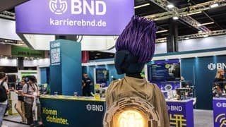 Cosplayerin „Operateurin AJ“ steht am Stand des BND und wartet auf Interessierte.