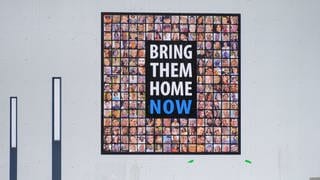 Ein Plakat mit Bildern der von der Hamas entführten Geiseln und dem Schriftzug „Bring them home now“ (Symbolbild)