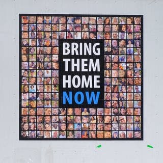 Ein Plakat mit Bildern der von der Hamas entführten Geiseln und dem Schriftzug „Bring them home now“ (Symbolbild)