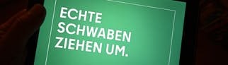 Der Werbeslogan „Echte Schwaben ziehen um“ einer Berliner Image Kampagne von der Agentur DOJO für Partner für Berlin GmbH  Senatskanzlei Berlin ist auf einem Tablett Bilschirm dargestellt. Baden-Württemberger werden mit dem Slogan auf Plakaten zum Umzug in die Hauptstadt aufgefordert.