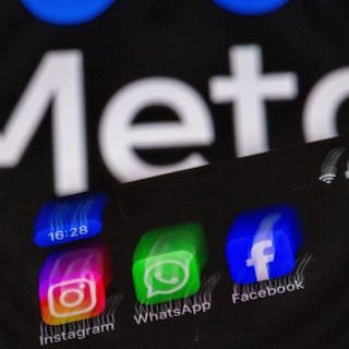 Man sieht die Logos von Facebook, Instagram und Whatsapp vor dem Logo ihres Mutterkonzerns Meta. Meta lässt jetzt auf seinen Diensten keine russischen Staatsmedien mehr zu.