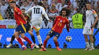 Spaniens Marc Cucurella bekommt den Schuss von Jamal Musiala an die Hand.