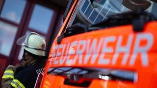 Ein Feuerwehrmann neben einem Löschfahrzeug - In Weingarten bei Ravensburg rettete ein Nachbar zwei Kinder aus einer brennenden Wohnung.