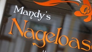 „Mandy's Nageloase“ steht auf einer Schaufensterscheibe; das Genitiv-s bei Eigennamen wurde bisher als Deppen-Apostroph bezeichnet