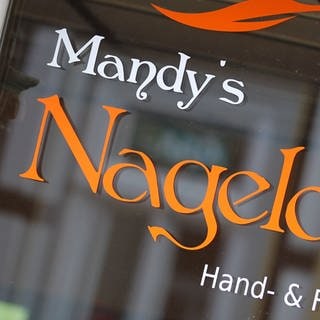 „Mandy's Nageloase“ steht auf einer Schaufensterscheibe; das Genitiv-s bei Eigennamen wurde bisher als Deppen-Apostroph bezeichnet