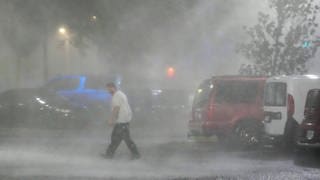 Hurrikan „Milton“ trifft auf den US-Bundesstaat Florida, ein Helfer läuft im heftigen Regen über einen Parkplatz