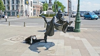 Skulptur eines Polizisten in Brüssel, der droht hinzufallen.