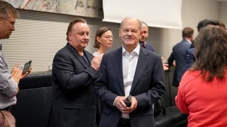 Ein lächelnder Bundeskanzler Olaf Scholz (SPD) nimmt nach der Entlassung des Bundesfinanzministers in einer Sonder-Fraktionssitzung seiner Partei den Applaus der Abgeordneten entgegen.