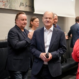 Ein lächelnder Bundeskanzler Olaf Scholz (SPD) nimmt nach der Entlassung des Bundesfinanzministers in einer Sonder-Fraktionssitzung seiner Partei den Applaus der Abgeordneten entgegen.