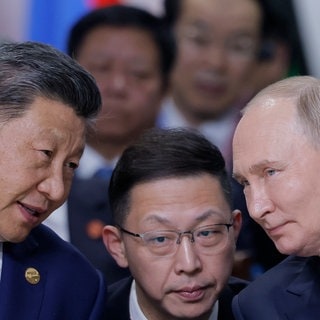 Der chinesische Präsident Xi Jinping (l) und der russische Präsident Wladimir Putin (r) sprechen während der Sitzung im OutreachBRICS Plus-Format auf dem BRICS-Gipfel in Kasan.