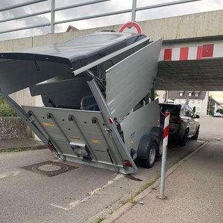 Auto mit Anhänger klemmt unter der Bahn-Unterführung in Mengen fest.