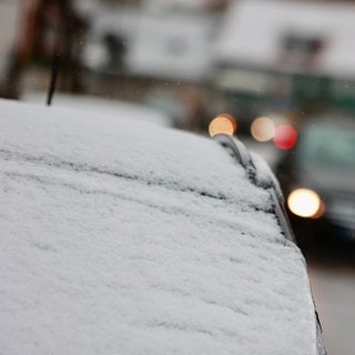 Auf einem Autodach ist Schnee liegen geblieben. In BW und RLP soll es am Mittwoch schneien.