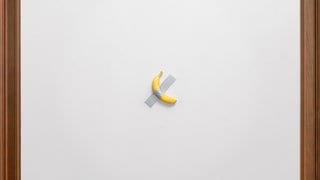 Eine Banane klebt mit Klebeband an der Wand, ein Kunstwerk von Maurizio Cattelan.