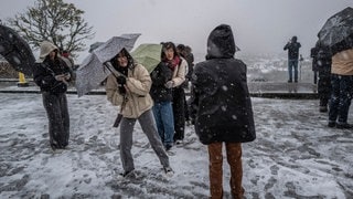 Frauen stellen sich mit ihren Regenschirmen gegen den Wind in Paris | Ein „Bomben-Zyklon“ soll Deutschland erreichen