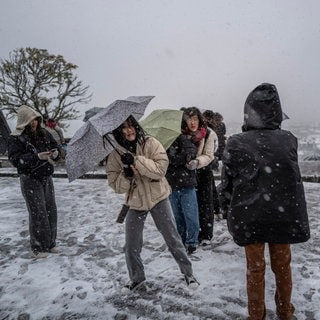 Frauen stellen sich mit ihren Regenschirmen gegen den Wind in Paris | Ein „Bomben-Zyklon“ soll Deutschland erreichen