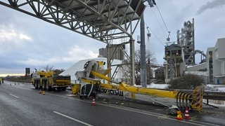 Ein Autokran ist an einer Schutzbrücke in Dotternhausen (Zollernalbkreis) hängengeblieben und umgestürzt. Er blockiert die Fahrbahn.