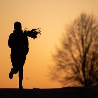 Eine Frau joggt vor dem Sonnenaufgang – So wird das Wetter nacht dem „Bomben-Zyklon“ in SWR3Land