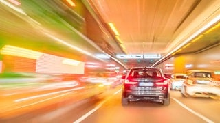 Autos fahren durch einen Tunnel. Wegen der Zunahme illegaler Straßenrennen fordert ein Berliner Verkehrsforscher, dass Männer den Führerschein erst ab 26 Jahren machen dürfen.