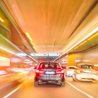 Autos fahren durch einen Tunnel. Wegen der Zunahme illegaler Straßenrennen fordert ein Berliner Verkehrsforscher, dass Männer den Führerschein erst ab 26 Jahren machen dürfen.