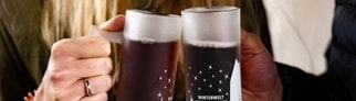 Zwei Menschen stoßen mit Glühwein an: Glühwein-Flaschen im Supermarkt sind oft nicht korrekt gekennzeichnet