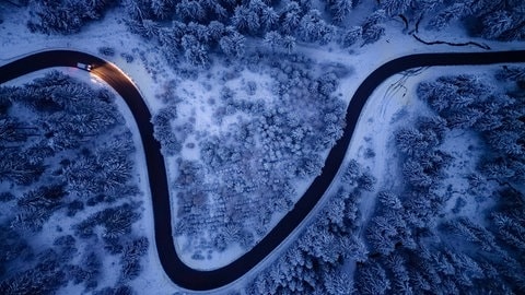 Drohnenaufnahme: Etwas Schnee liegt auf den Bäumen und Straßen in den Mittelgebirgen, hier hat sich der Winter schon bemerkbar gemacht.