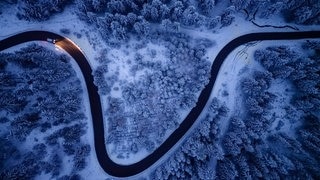 Drohnenaufnahme: Etwas Schnee liegt auf den Bäumen und Straßen in den Mittelgebirgen, hier hat sich der Winter schon bemerkbar gemacht.