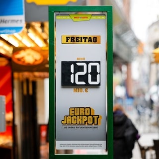 „120 Millionen Euro“ im Eurojackpot steht auf einer Tafel vor einer Lotto-Annahmestelle.