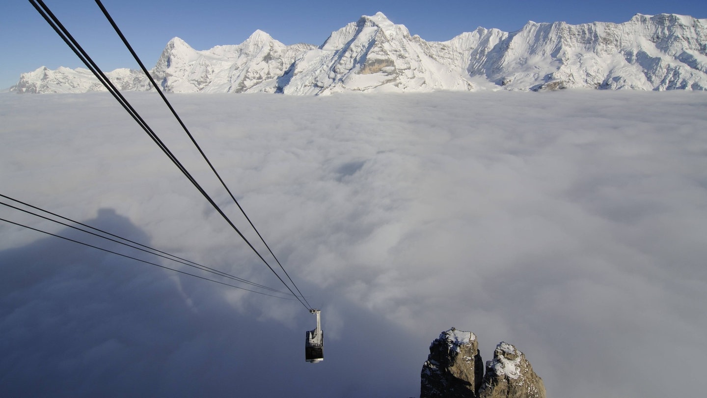 Schilthornbahn über einer Wolkendecke in den Berner Alpen.