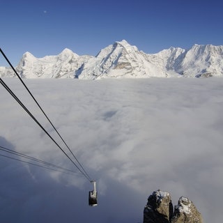 Schilthornbahn über einer Wolkendecke in den Berner Alpen.