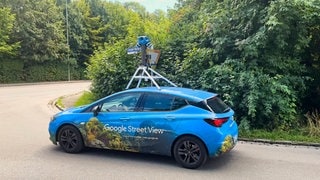 Google Street View-Auto unterwegs: Mann steht vor einem Kofferraum. Das Foto hat der Polizei in Spanien bei Mordermittlungen geholfen. Im Kofferraum liegt offenbar ein Leichensack.