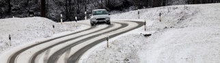 Auto auf schneebedeckter Straße: Beim Reiseverkehr an Weihnachten muss in Höhenlagen auf Glatteis und Schneefall geachtet werden