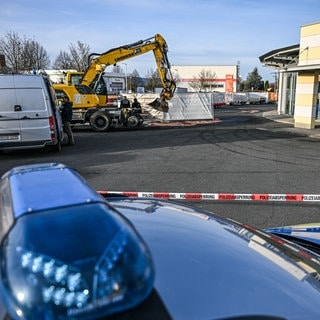 Ein Bagger steht nach einer Zerstörungsfahrt neben einem Autohaus in Tauberbischofsheim.