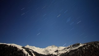 Man sieht einen Regen von Sternschnuppen am Nachthimmel.