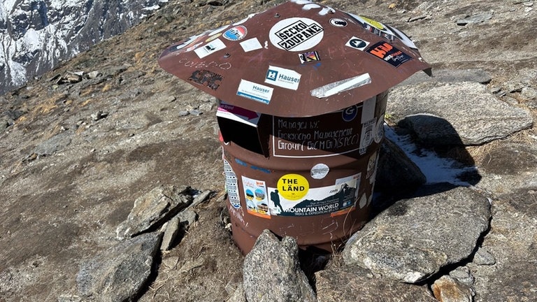 Ein „The Länd“-Aufkleber klebt an einer Tonne auf dem Gokyo Ri in Nepal.