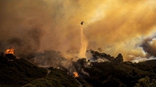 Ein Hubschrauber wirft im Stadtteil Pacific Palisades von Los Angeles Wasser auf das sich ausbreitende Palisades-Feuer.