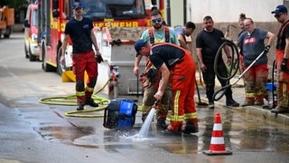 Feuerwehr pumpt Wasser aus einem Haus. Sie fordert die Menschen sollten sich besser auf Unwetter, Notfälle und Katastrophen vorbereiten