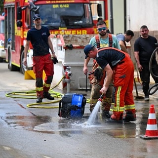 Feuerwehr pumpt Wasser aus einem Haus. Sie fordert die Menschen sollten sich besser auf Unwetter, Notfälle und Katastrophen vorbereiten