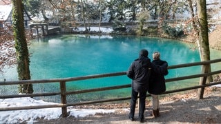 Zwei Besucher schauen auf den Blautopf. Jetzt ist er trotz Baustelle wieder täglich zugänglich.