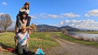 Johnny, Liam und Ryan posieren neben einem Kajak. Sie reisen von Dublin nach Istanbul, um Spenden für Kinder mit Krebs zu sammeln. 