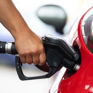 Eine Frau tankt in einer Tankstelle.