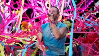 Frontsänger Chris Martin der Band Coldplay bei einem Konzert während sein Vater stolz mitfiebert