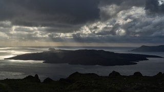 Sonnenstrahlen beleuchten das vulkanische Eiland Nea Kameni, das zur Insel Santorini gehört, die gerade von Erdbeben betroffen ist. Derzeit bebt die Erde auf der Insel fast im Zehn-Minuten-Takt. Das betreffende Beben erreichte mit Stärke 5 einen vorläufigen Höchstwert.