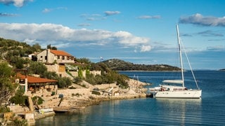 Kroatien: Insel Kaprije - man sieht eine Yacht in einem einsamen kleinen Hafen.