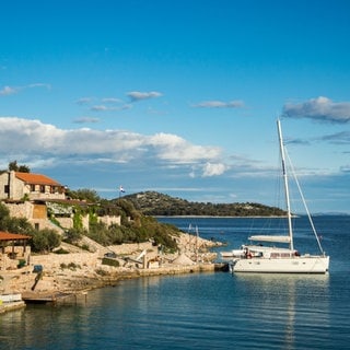 Kroatien: Insel Kaprije - man sieht eine Yacht in einem einsamen kleinen Hafen.