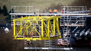 Stück für Stück werden die beiden Enden der Brücke über das Tal geschoben.