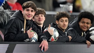 Nations-League-Spiel Deutschland - Italien: Balljunge Noel Urbaniak (ganz links) und weitere Balljungen sitzen hinter der Bande.