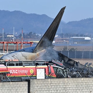 Feuerwehrleute und Mitglieder eines Rettungsteams arbeiten auf der Start- und Landebahn des internationalen Flughafens Muan. Bei der Landung am internationalen Flughafen von Muan in Südkorea ist ein Passagierflugzeug verunglückt.