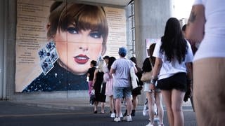 Fans von Taylor Swift stehen vor einem Wandgemälde der Sängerin Schlange, um Fotos zu machen. Sie ist ein Vorbild für viele Swifties.