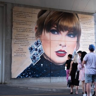 Fans von Taylor Swift stehen vor einem Wandgemälde der Sängerin Schlange, um Fotos zu machen. Sie ist ein Vorbild für viele Swifties.